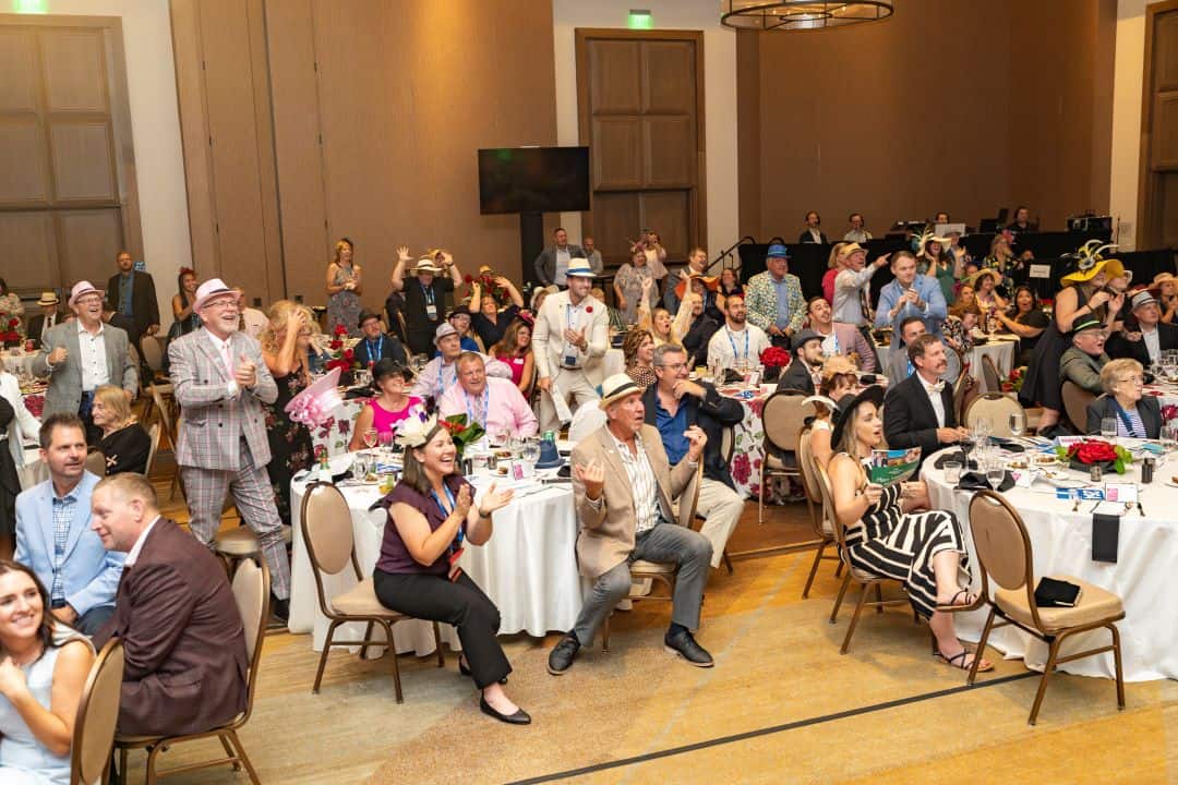 IHS Conference attendees are dressed in Kentucky Derby themed attire and watching a race