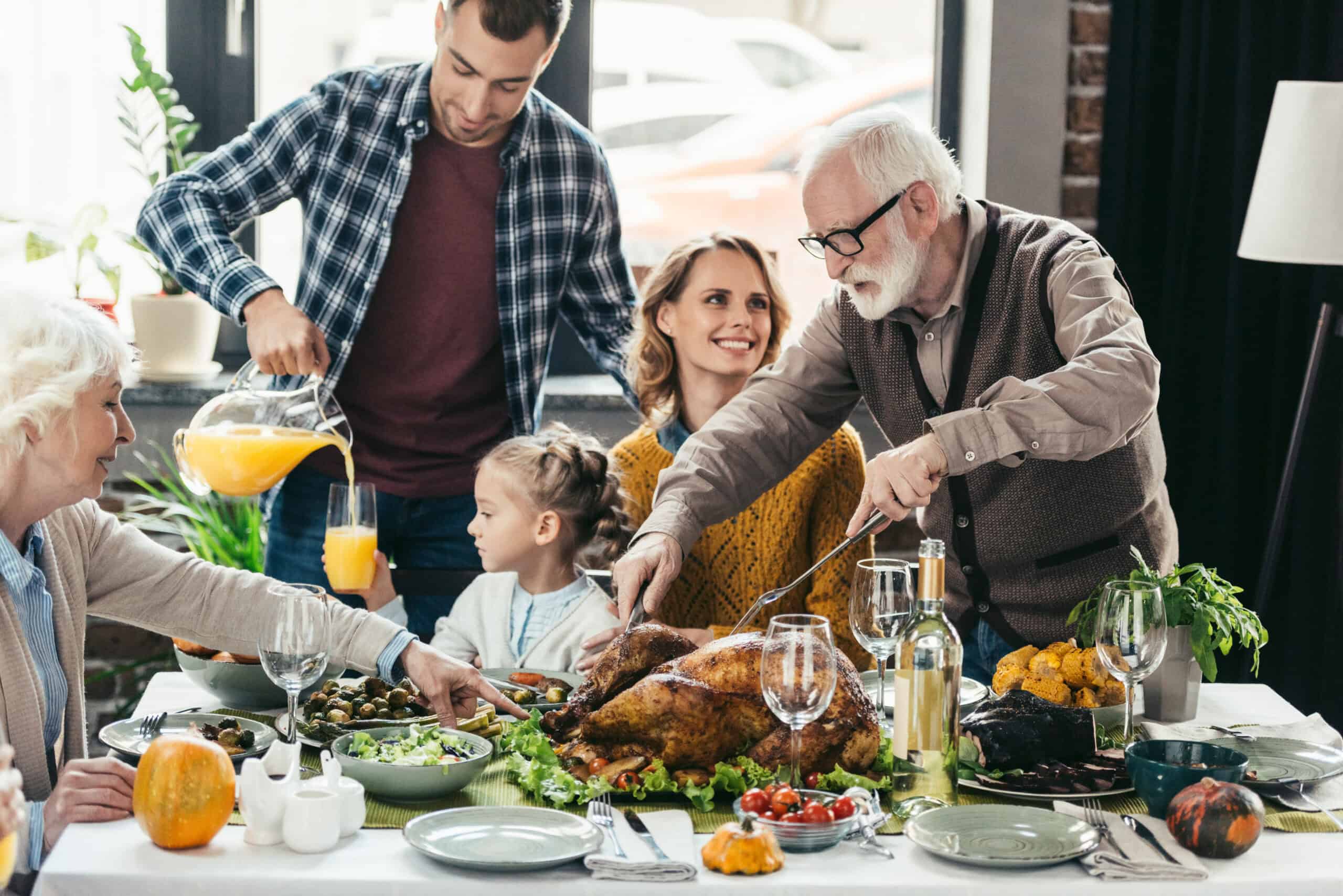 Family enjoying a festive meal with a roasted turkey, emphasizing the importance of ear protection