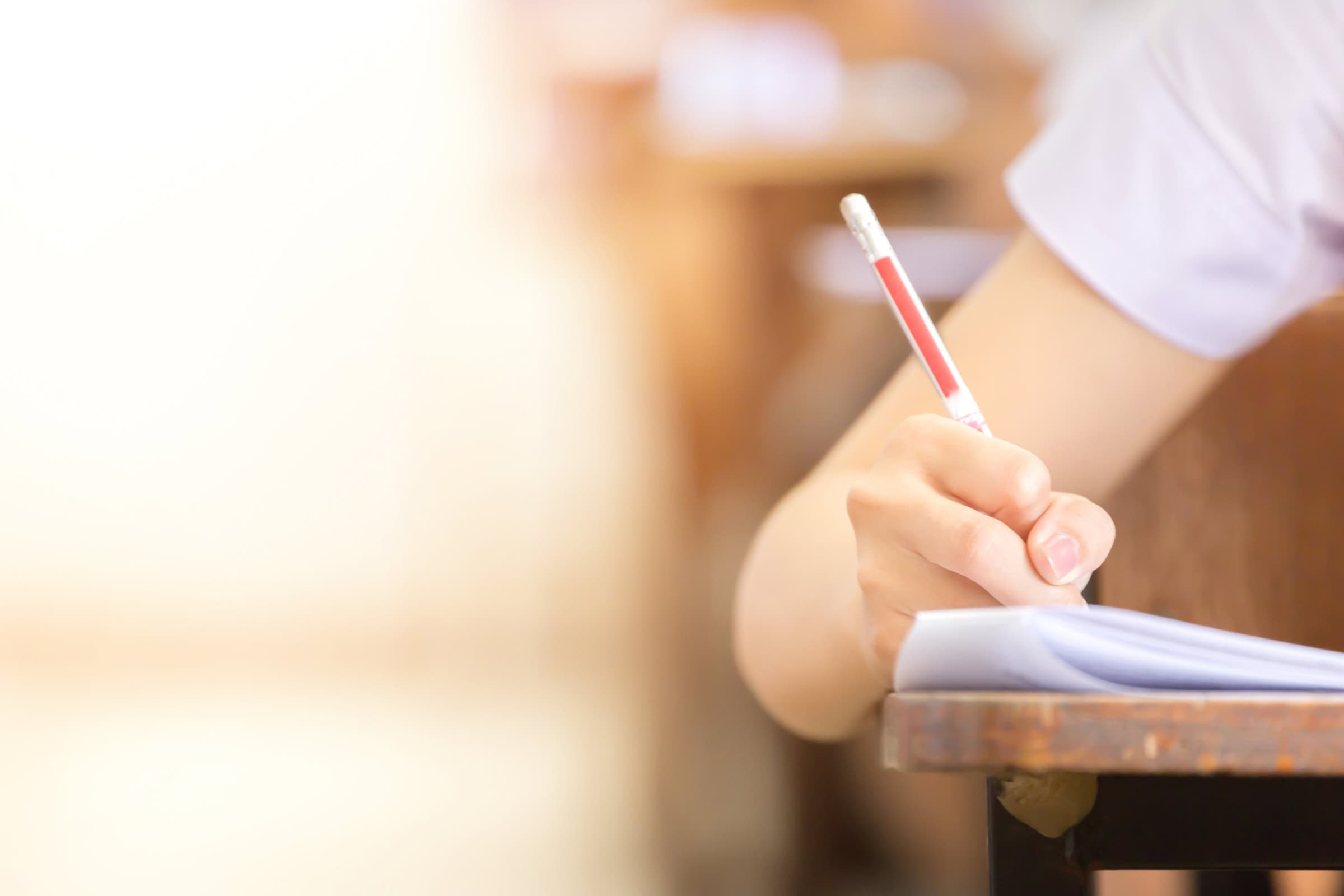 a student writing on a document with a pencil