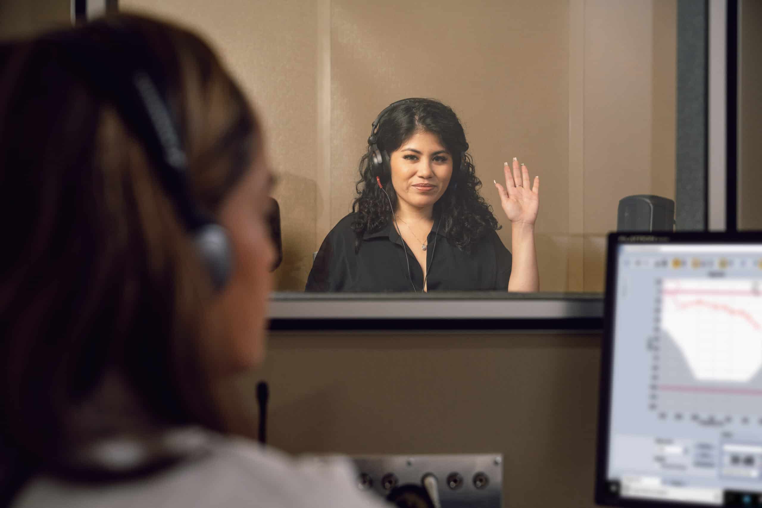 a woman in a booth during a hearing evaluation