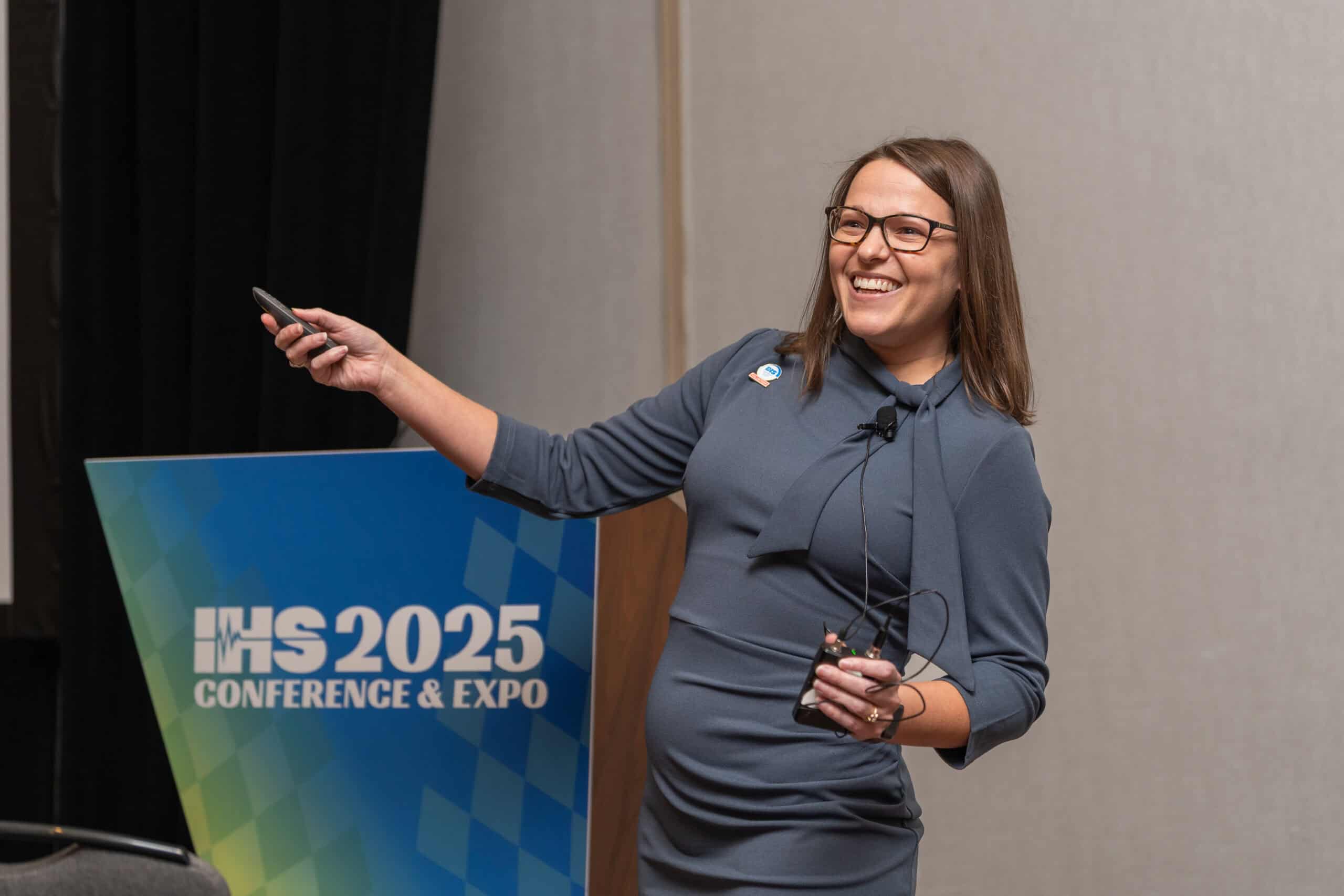 speaker pointing in front of a podium