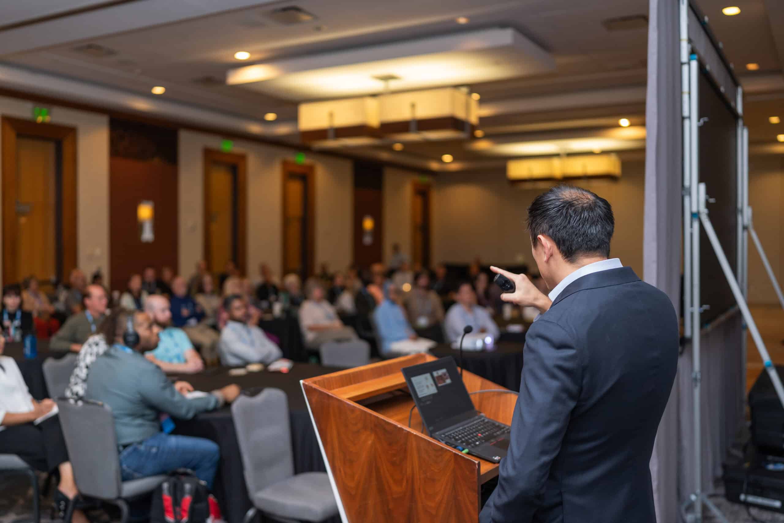 speaker presenting in front of a large audience