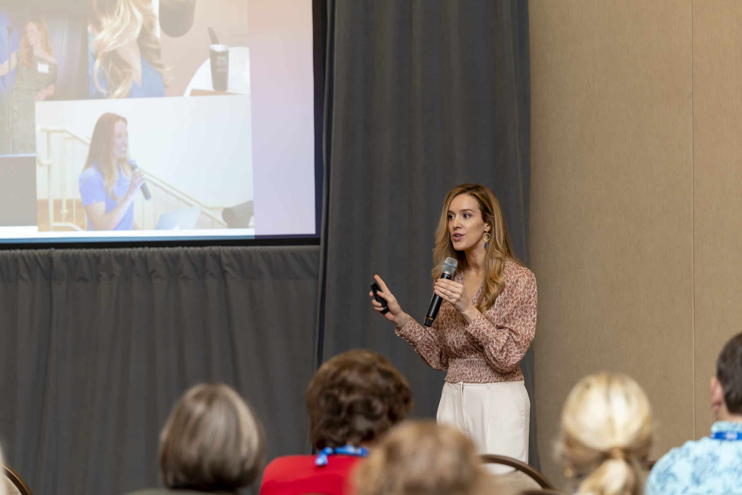 Woman presenting slides during a conference session.