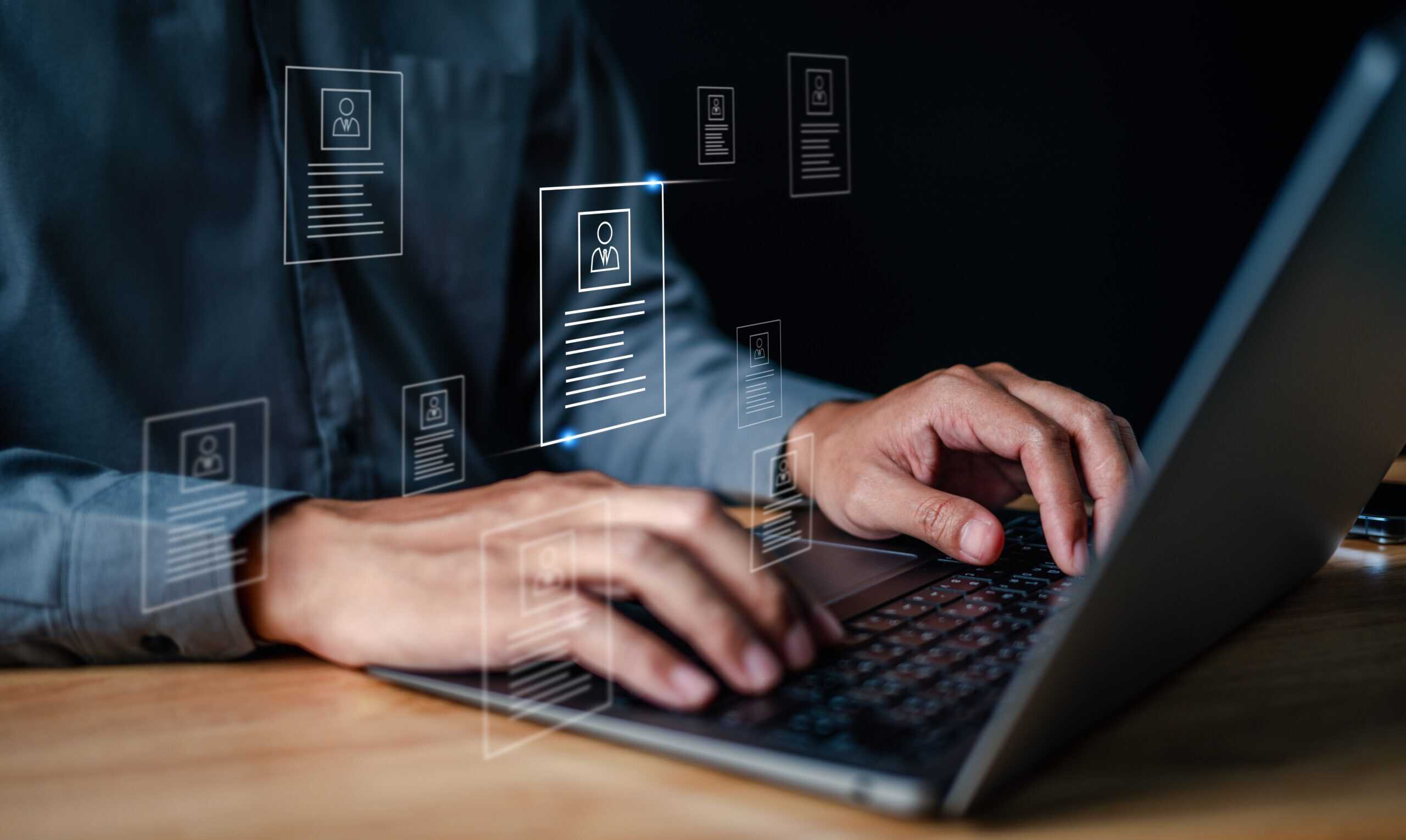 Closeup of man typing on a laptop with account profile imagery
