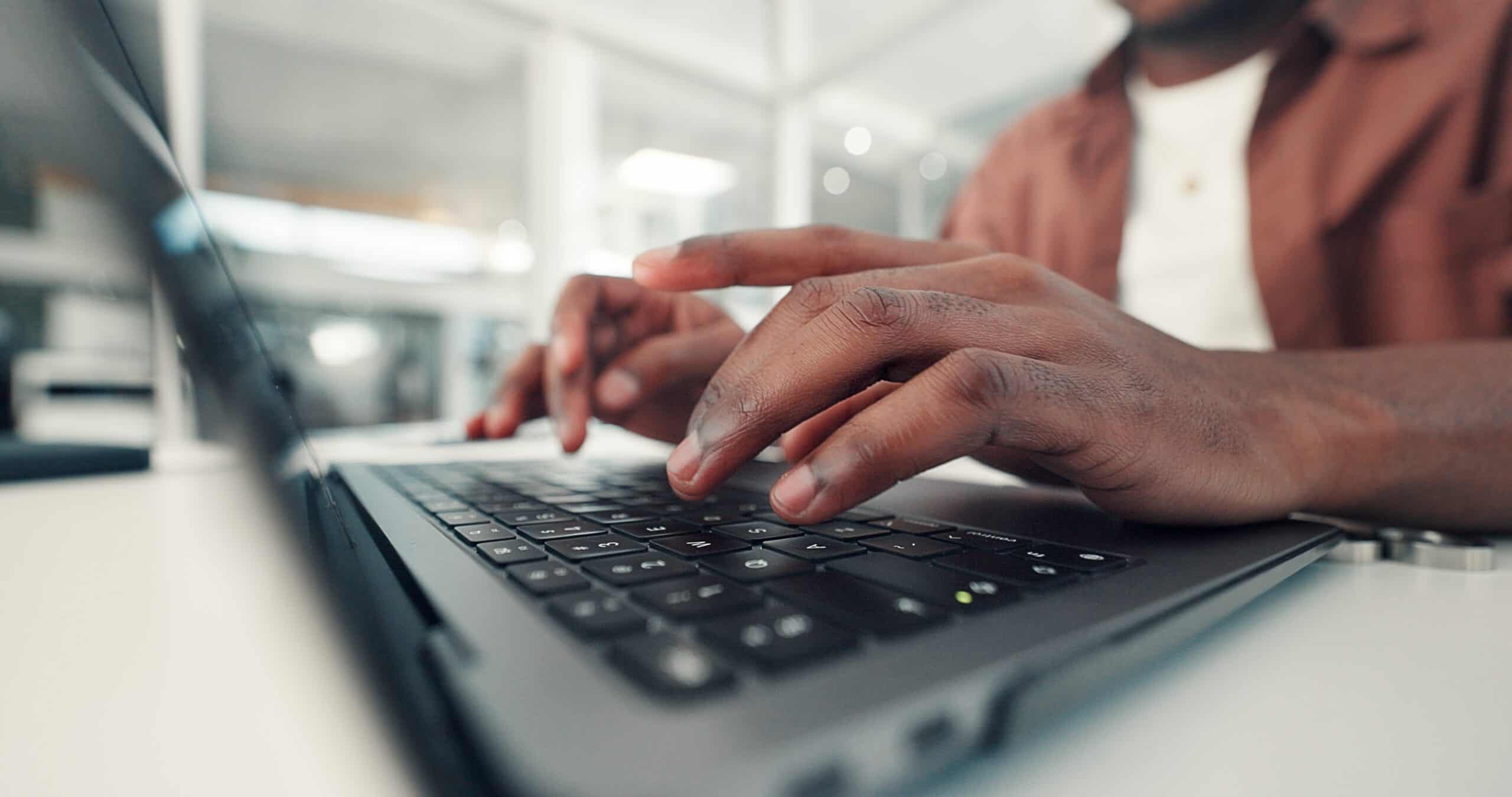 Person typing on a laptop, preparing to become a speaker.