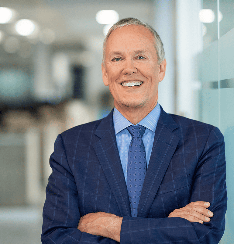 Dave Fabry, PhD, in a suit, smiling confidently in an office setting.