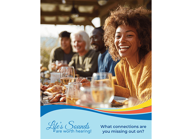 Group of people enjoying a meal and drinks outdoors, smiling and socializing.