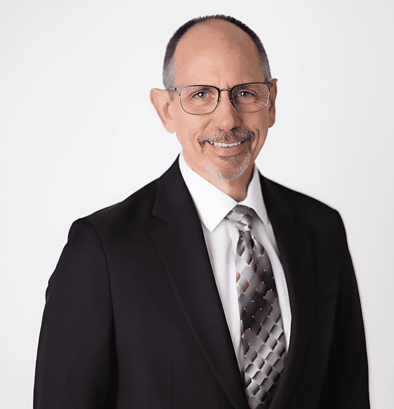 Headshot of Wesley Miller, ACA, BC-HIS, wearing a black suit and tie, smiling.