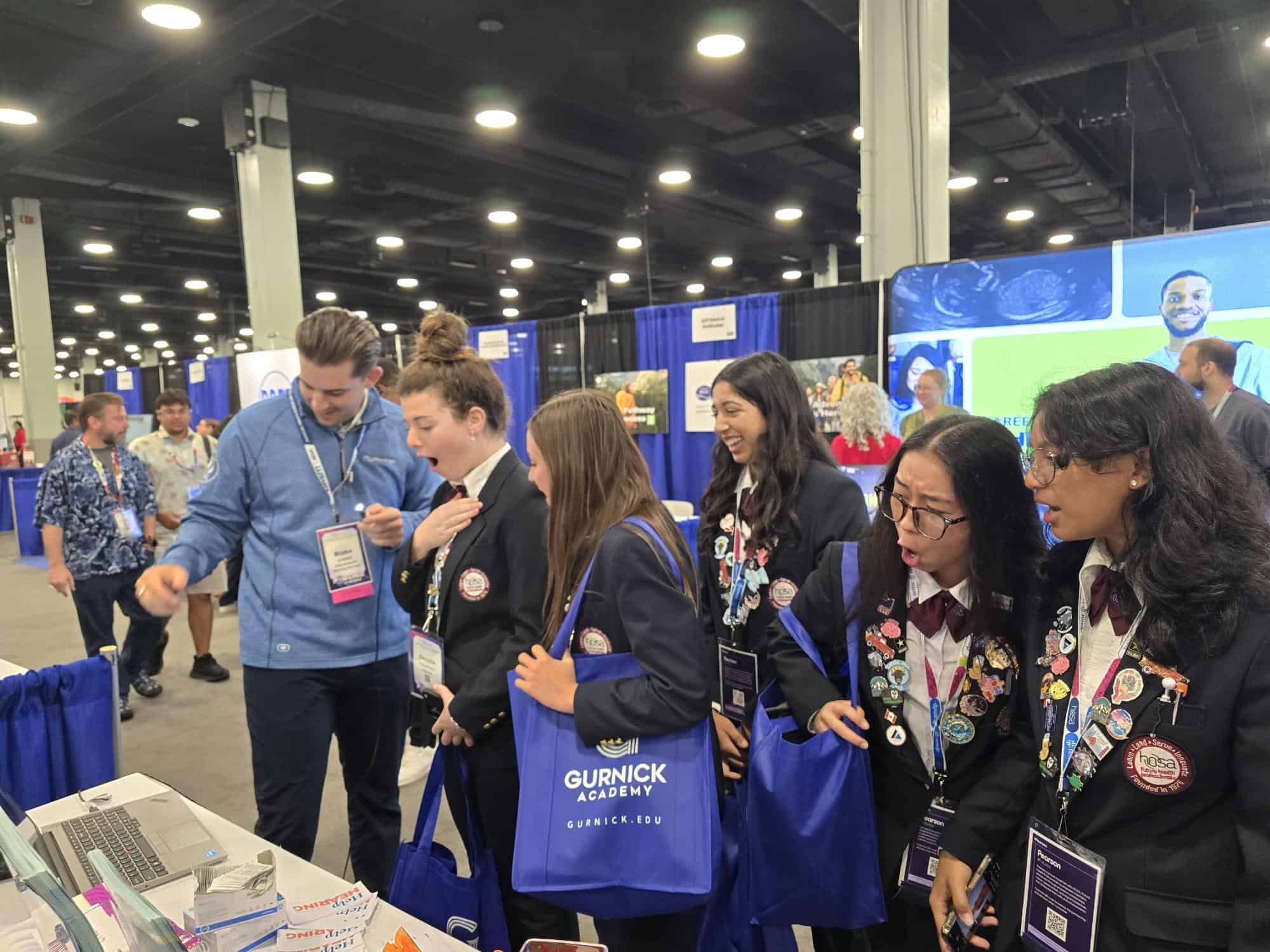 IHS Member Blake Cordell, BC-HIS showing high school students what the inside of an ear looks like.