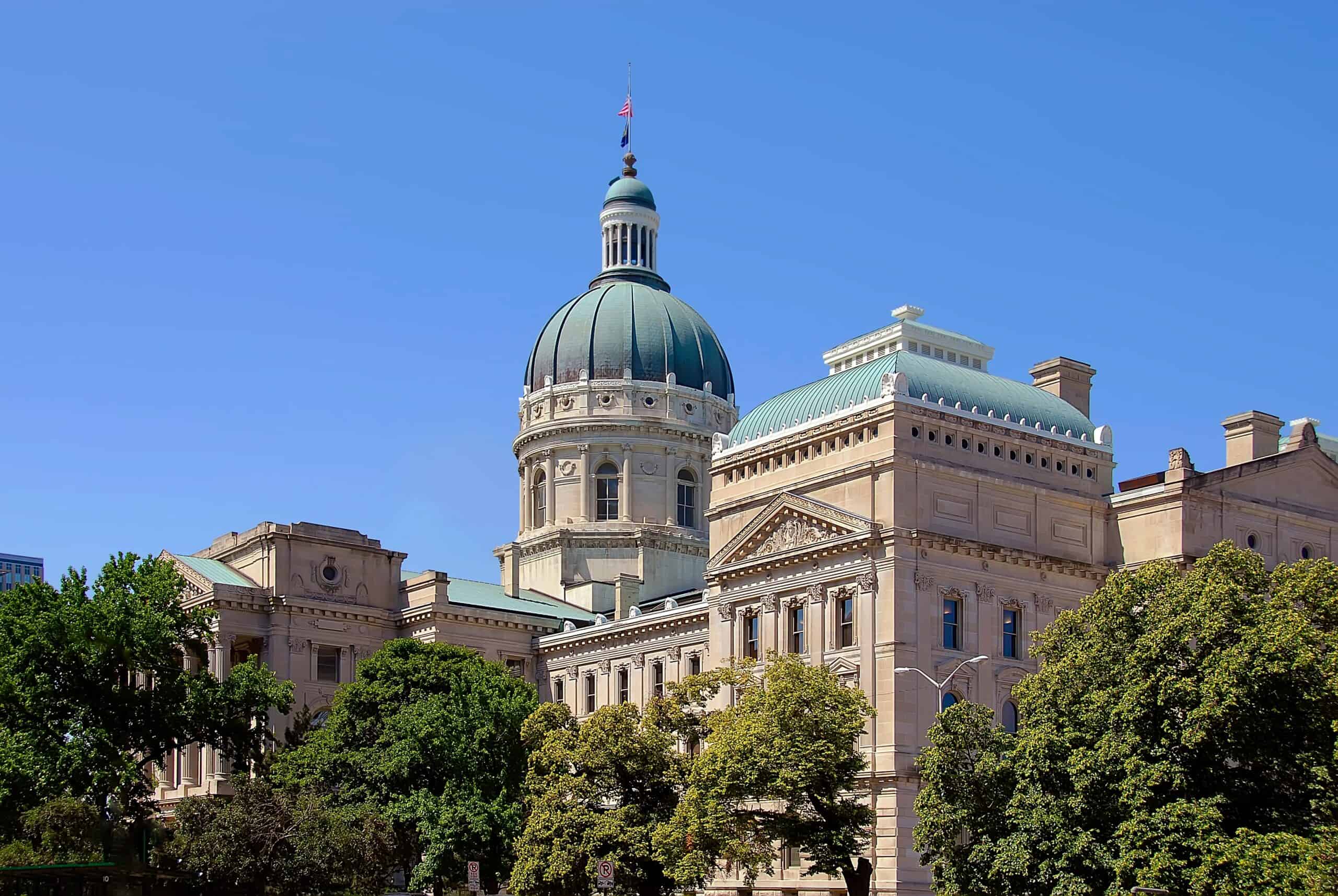 Indiana Statehouse dome and architecture against a clear blue sky.