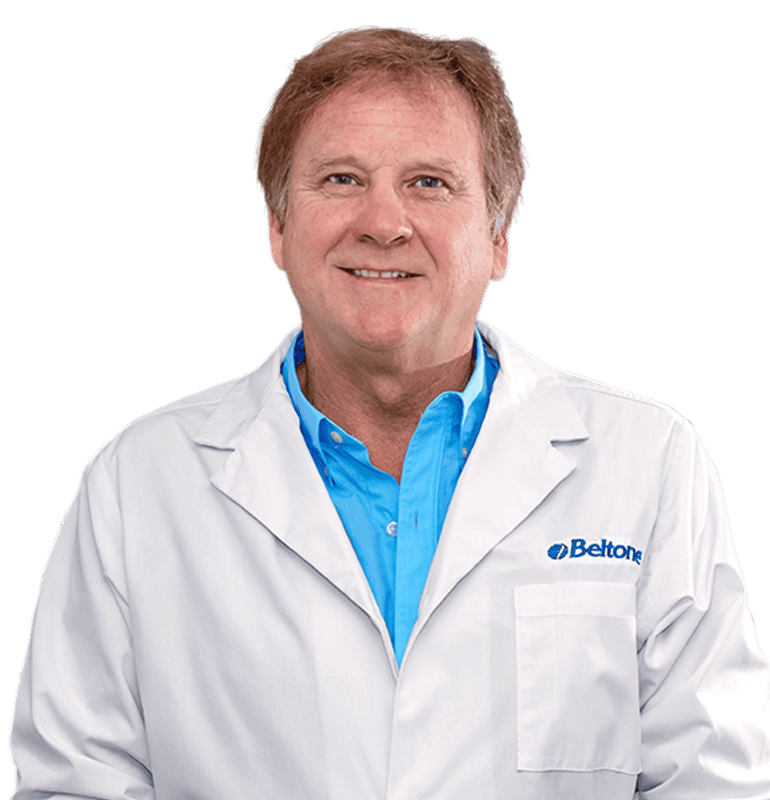 Annette Cross, BC-HIS, wearing a white lab coat with the Beltone logo, smiling.