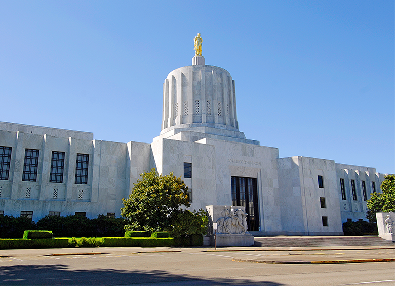 Oregon State Capitol building featuring the Oregon Pioneer statue on a clear day.