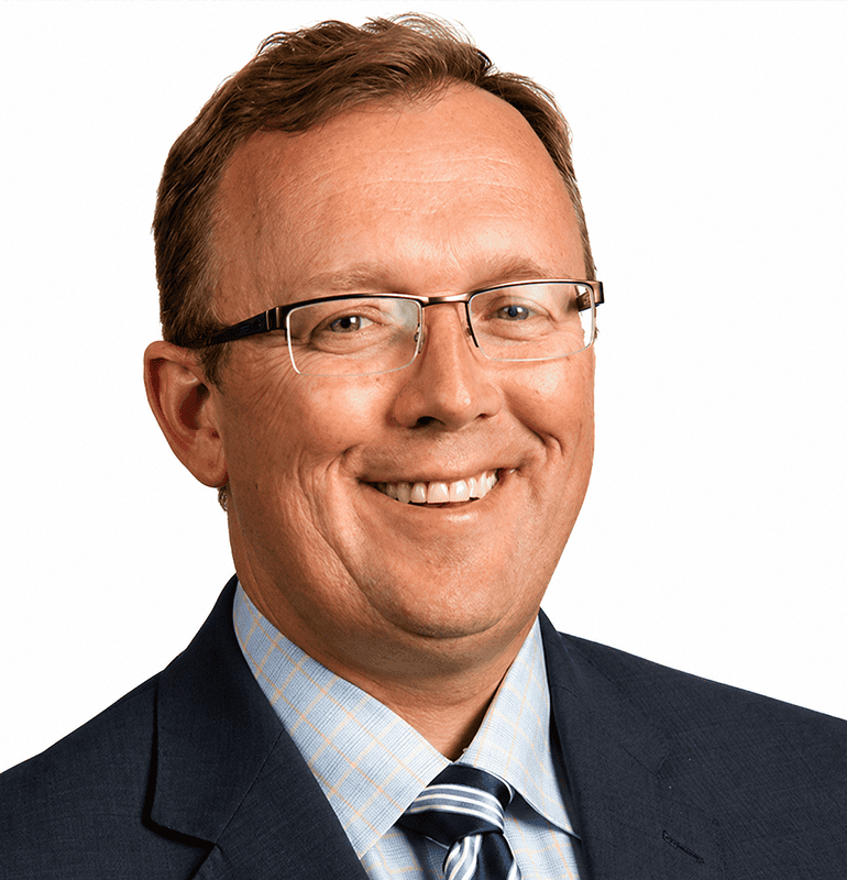 Dr. Brian Taylor smiles in a professional portrait wearing a suit and glasses.
