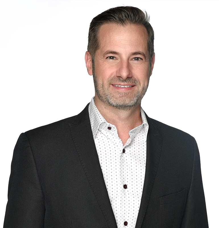 Professional in a suit and patterned white shirt, smiling