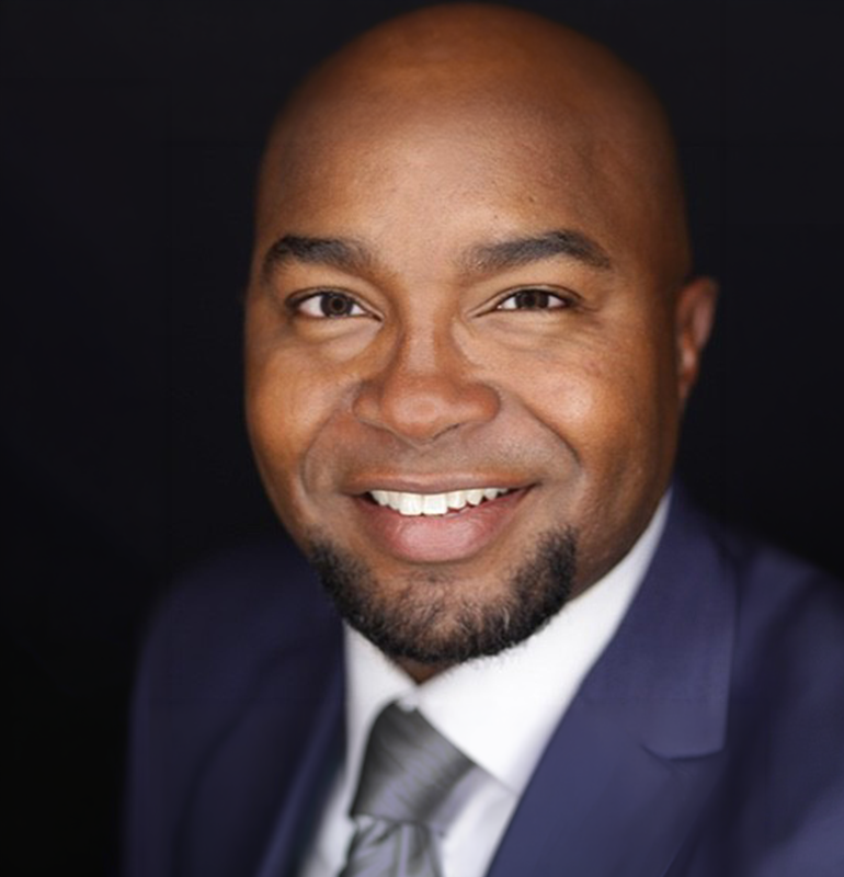 Portrait of Michael D. Guiden, a smiling man in a blue suit.